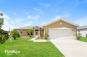 Kissimmee house for rent - a beige house with a garage and a lawn