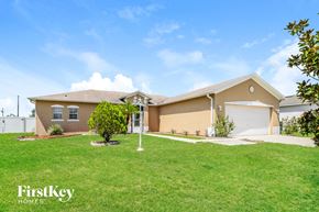 Kissimmee house for rent - a beige house with a lawn and a garage