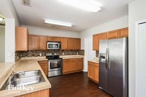 Kissimmee house for rent - a kitchen with wooden cabinets and stainless steel appliances