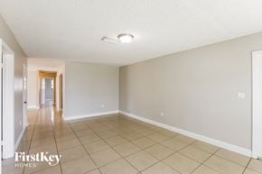 Hollywood house for rent - A spacious room with a tiled floor and a doorway leading to another room.