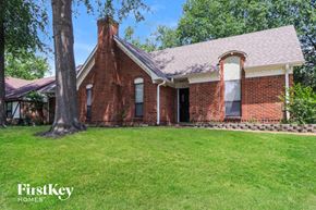 Memphis house for rent - an old brick house with a grass lawn and a tree