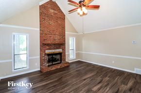 Memphis house for rent - a living room with a brick fireplace and a ceiling fan