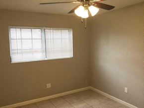 Miami Gardens house for rent - a bedroom with a ceiling fan and a window