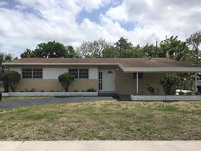 Miami Gardens house for rent - the front of a house with a lawn and a driveway