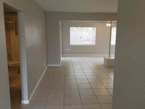 Miami Gardens house for rent - an empty living room with a tiled floor and a window