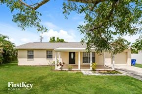 Fort Myers house for rent - A house with a white front porch and a tree branch in the foreground.