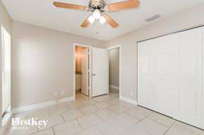 Fort Myers house for rent - A spacious room with a ceiling fan and two doors.