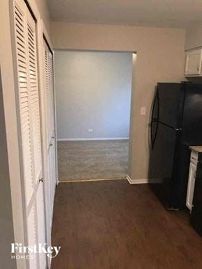 Aurora house for rent - a hallway with a black refrigerator and a door