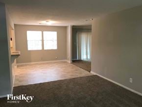 Stone Mountain house for rent - A spacious room with a carpeted floor and a door leading to another room.