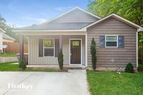 Kannapolis house for rent - A small house with a brown door and a brown fence.