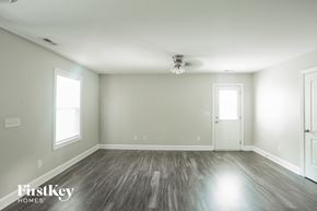 Kannapolis house for rent - A spacious room with wooden flooring and a ceiling fan.