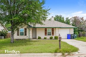 Azle house for rent - a small white brick house with a tree and a parking meter