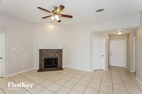 Azle house for rent - a living room with a fireplace and a ceiling fan