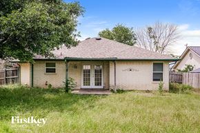 Azle house for rent - the front of a brick house with a yard and grass
