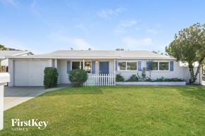 Phoenix house for rent - a white house with blue shutters and a lawn