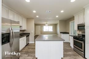 Phoenix house for rent - a kitchen with white cabinets and stainless steel appliances