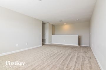 Ruskin house for rent - a spacious living room with carpet and white walls