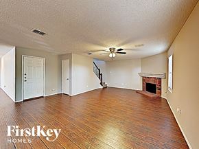 Arlington house for rent - A spacious room with wood flooring and a fireplace.
