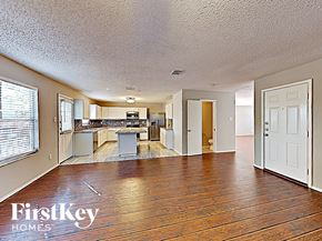 Arlington house for rent - A spacious living room with wooden floors and a kitchen in the background.