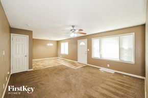 Raytown house for rent - A spacious room with a carpeted floor and a ceiling fan.