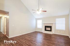 Peculiar house for rent - A spacious room with a fireplace and a ceiling fan.