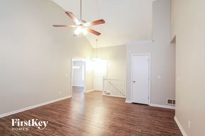 Peculiar house for rent - A spacious room with a ceiling fan and wooden flooring.