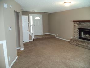 Indianapolis house for rent - a living room with a fireplace and a carpeted floor