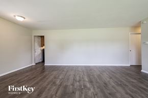 Indianapolis house for rent - A spacious room with wooden flooring and two doors.