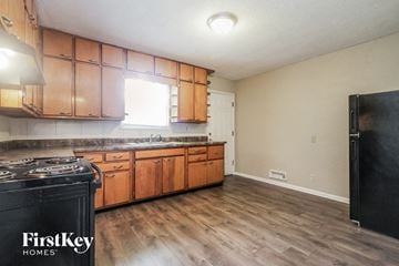 Indianapolis house for rent - A kitchen with wooden cabinets and a black stove top.