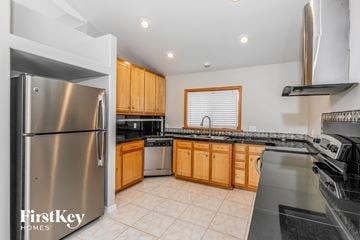 Oviedo house for rent - a kitchen with stainless steel appliances and wooden cabinets