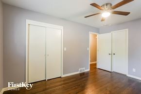 Blue Springs house for rent - a bedroom with three closet doors and a ceiling fan
