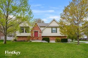 Lee's Summit house for rent - a home with a green lawn and a red door