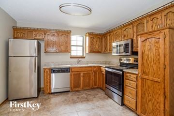 Lee's Summit house for rent - a kitchen with wooden cabinets and stainless steel appliances