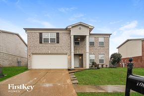 Cordova house for rent - a brick house with a white garage door and a green lawn
