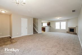 Cordova house for rent - a living room with a fireplace and a carpeted floor
