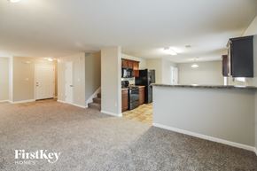 Cordova house for rent - a kitchen and living room with a granite counter top and a black refrigerator and microwave