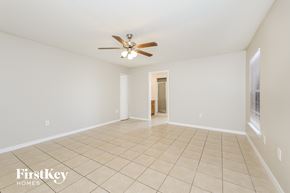 Dundee house for rent - a spacious living room with tile flooring and a ceiling fan