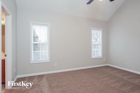 Knightdale house for rent - a bedroom with a carpeted floor and two windows
