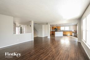 Indianapolis house for rent - A spacious living room with wood flooring and a staircase leading to another room.