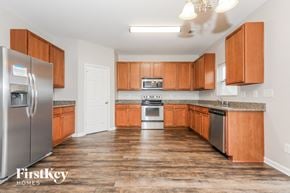 Indian Trail house for rent - a kitchen with wooden cabinets and stainless steel appliances