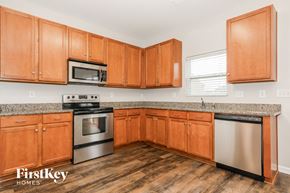 Indian Trail house for rent - a kitchen with wooden cabinets and granite counter tops and stainless steel appliances