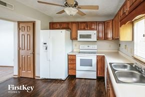 Fishers house for rent - a kitchen with white appliances and wooden cabinets