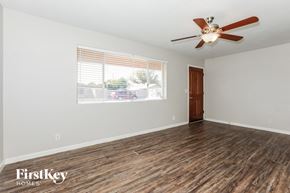 Mesa house for rent - an empty living room with a large window and a ceiling fan