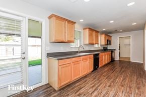 Mesa house for rent - a kitchen with wooden cabinets and a door leading to a patio