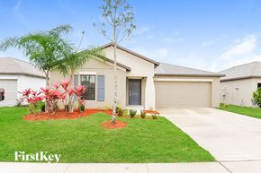 Riverview house for rent - a home with a lawn and palm tree in front of it