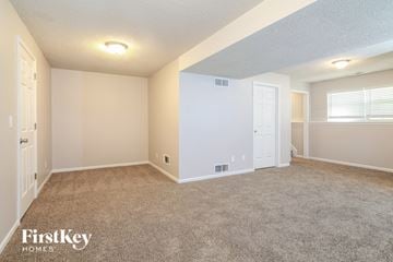 Greenwood house for rent - the living room of a home with carpet and a white door