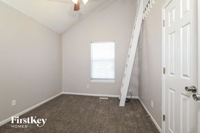 Greenwood house for rent - a bedroom with a staircase and a window and a carpeted floor
