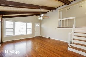 Oak Lawn house for rent - an empty living room with wood floors and a ceiling fan
