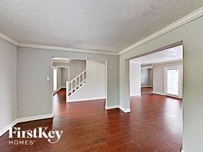 Conroe house for rent - the living room and dining room of an empty house with wood floors