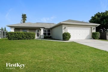 Cape Coral house for rent - a home with a lawn and a white garage door